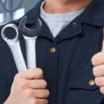 Auto mechanics holding wrenches and keys.