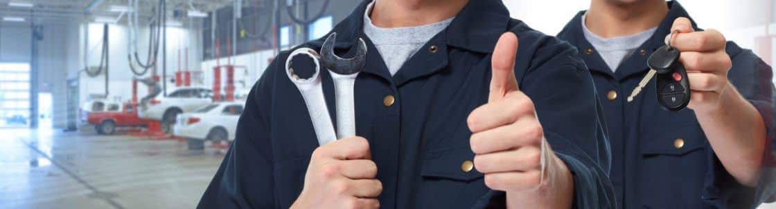 Auto mechanics holding wrenches and keys.